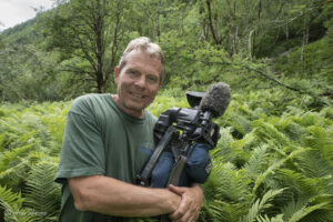 Naturfotograf og filmskaper Arne Nævra i en bregneskog med videokameraet. Bildetv er tatt under opptak til TV-serien "#Min Natur" som ble vist på NRK i 2017.